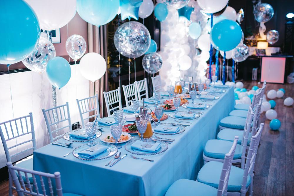 Grande table de baptême bleue et blanche décorée de ballons