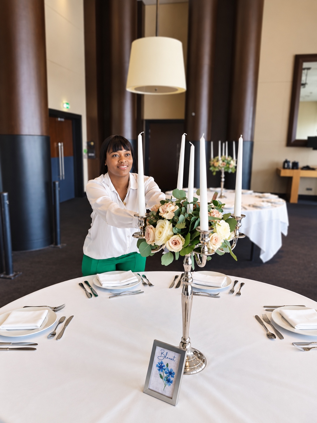 WIDIANE finalisant un centre de table fleuri avec chandeliers