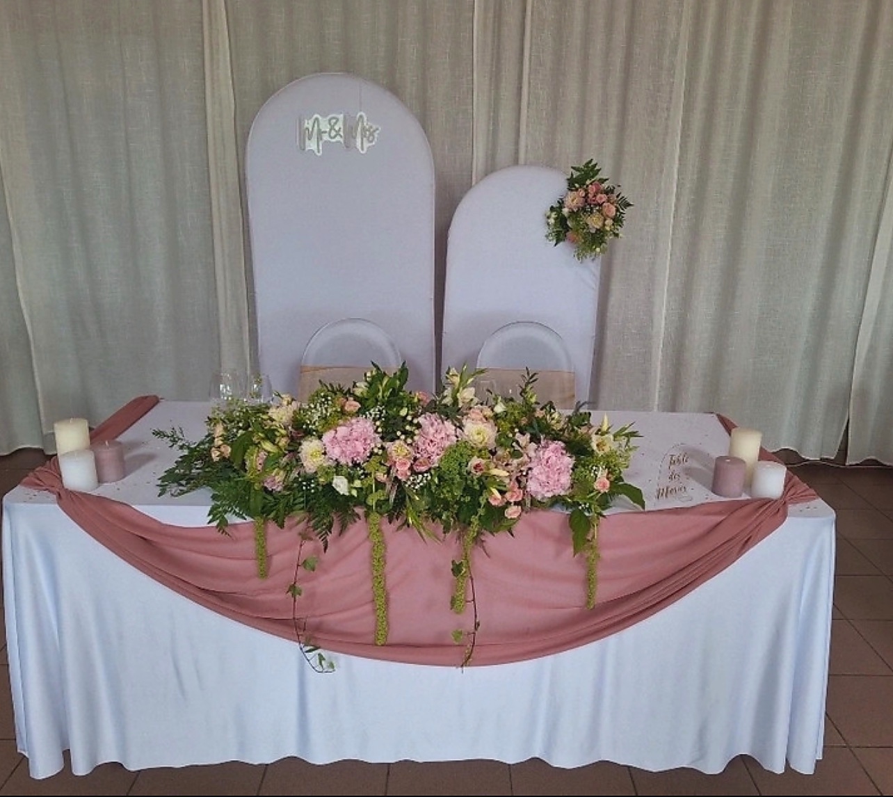Table d’honneur rose poudré décorée de fleurs et de verdure
