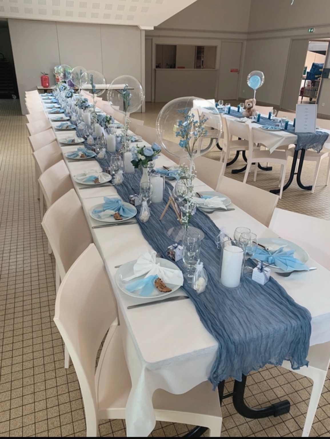 Longue table de réception décorée dans des tons bleu et blanc